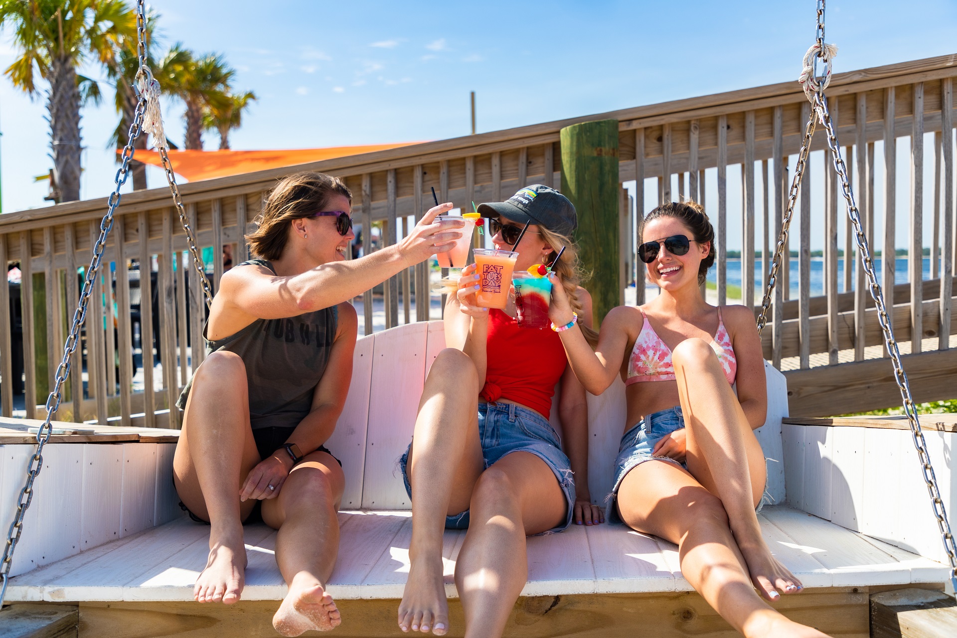 Girls cheering with frozen drinks at Laguna's Beach Bar + Grill 