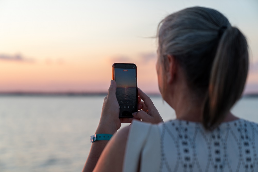 Woman taking sunset photo Woman taking sunset photo
